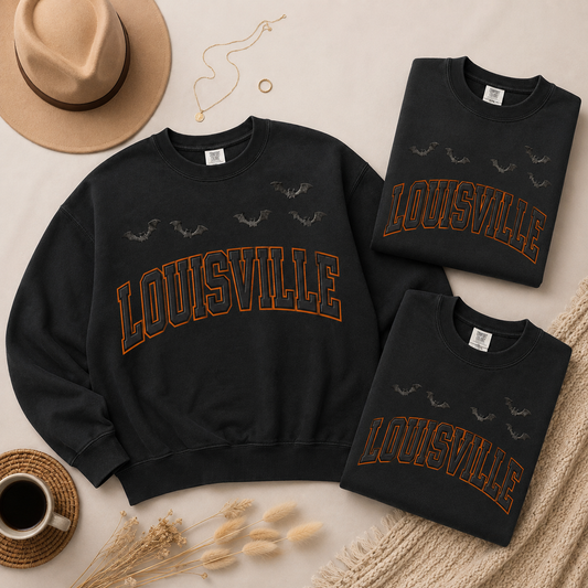 Louisville Halloween blackout crewnecks in Black — three-sweatshirt flat lay with felt hat, necklace and coffee