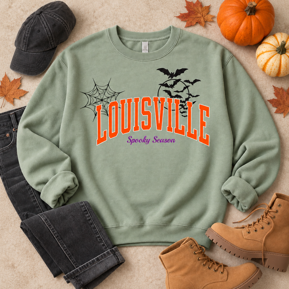 Louisville Spooky Season crewneck in Sage — styled fall flat lay with pumpkins, leaves and boots