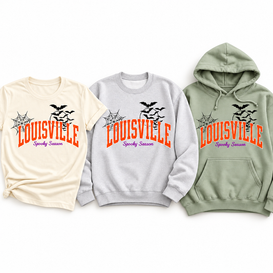 Louisville Spooky Season design on all three styles — Ivory tee, Heather Grey crewneck and Sage hoodie