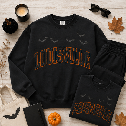 Louisville Halloween blackout crewneck and folded tee in Black — fall flat lay with pumpkins, candle and sweatpants